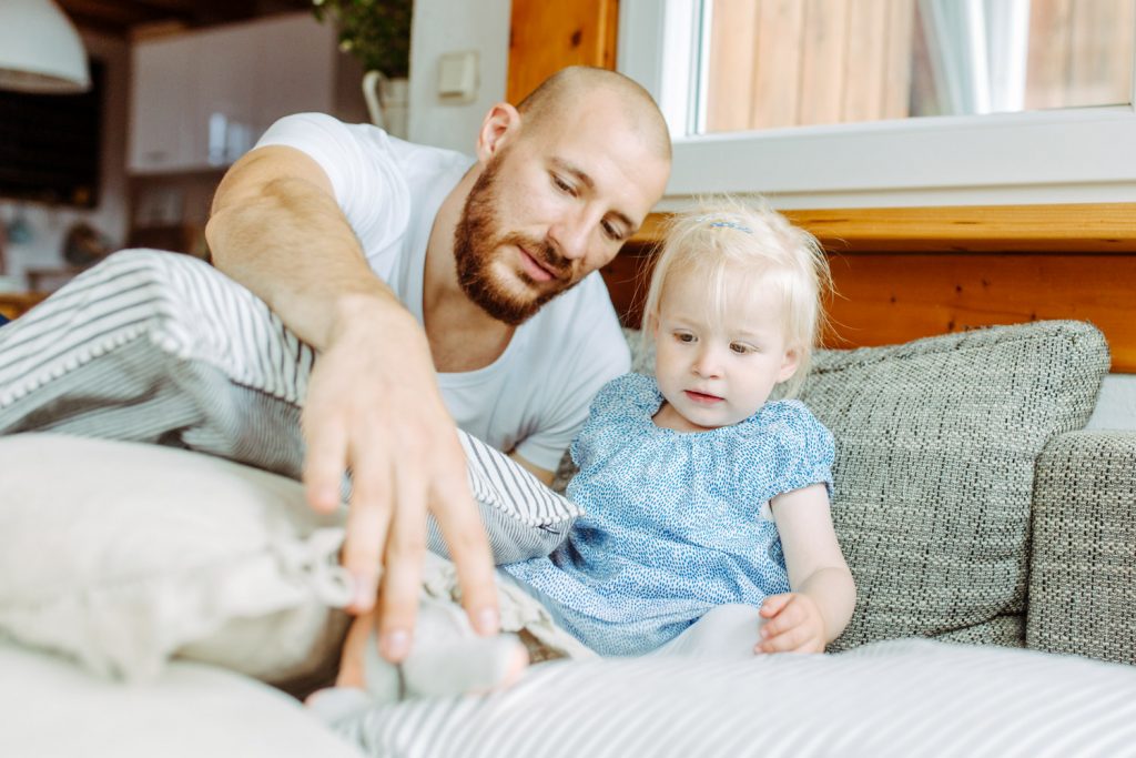 Vater und Mädchen spielen auf der Couch