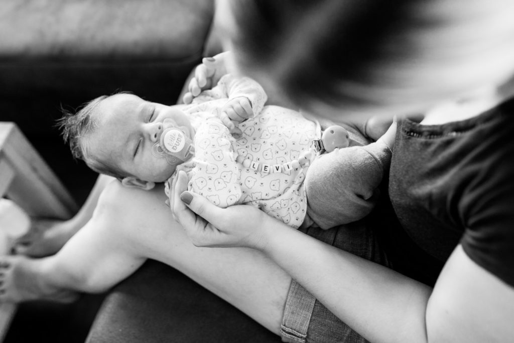 Baby mit Schnuller auf Mamas schoß
