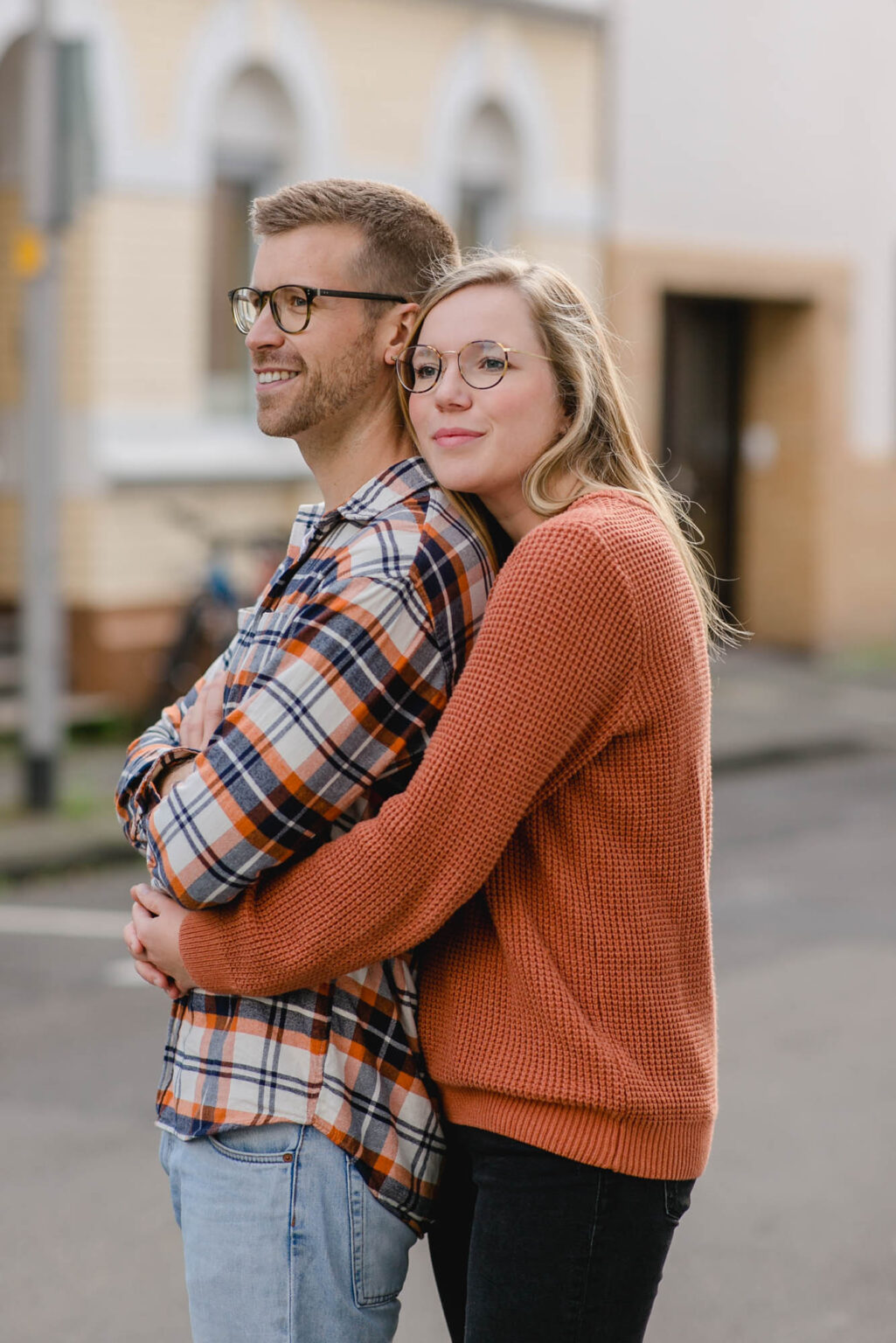 Mann und Frau stehen Arm in Arm und schauen in die Ferne.